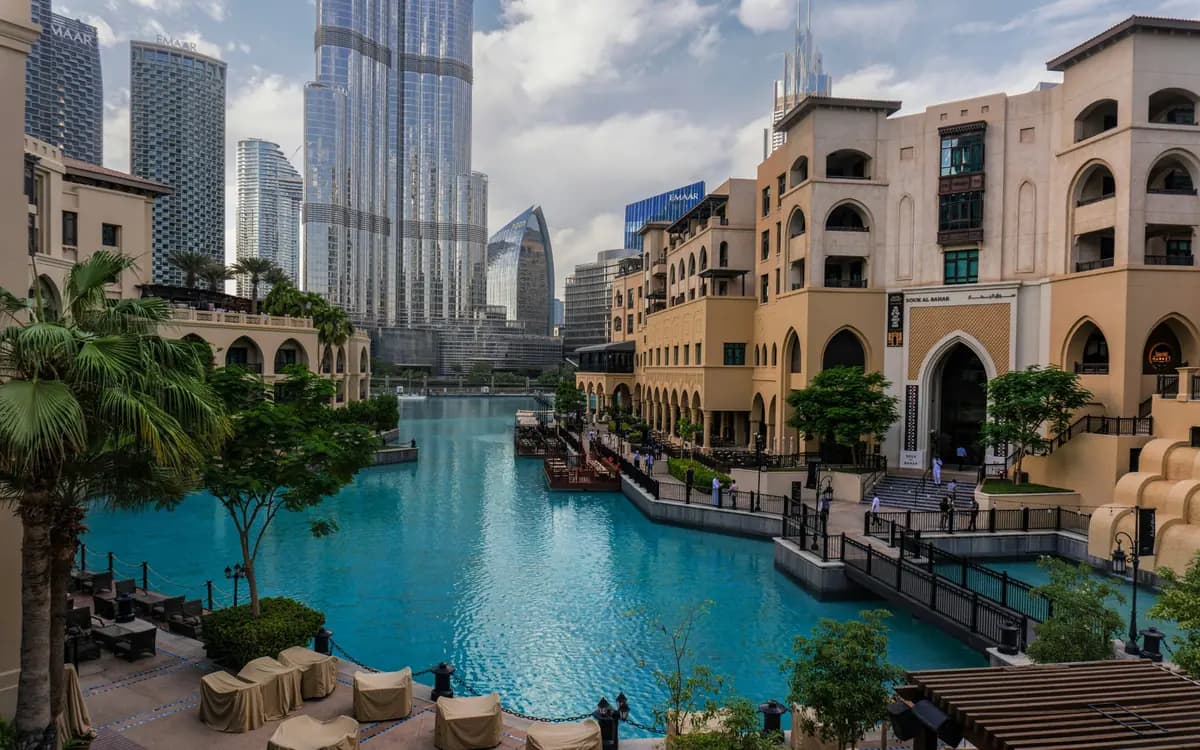 Downtown Dubai waterfront with Burj Khalifa, modern towers, turquoise water, and hospitality district architecture.