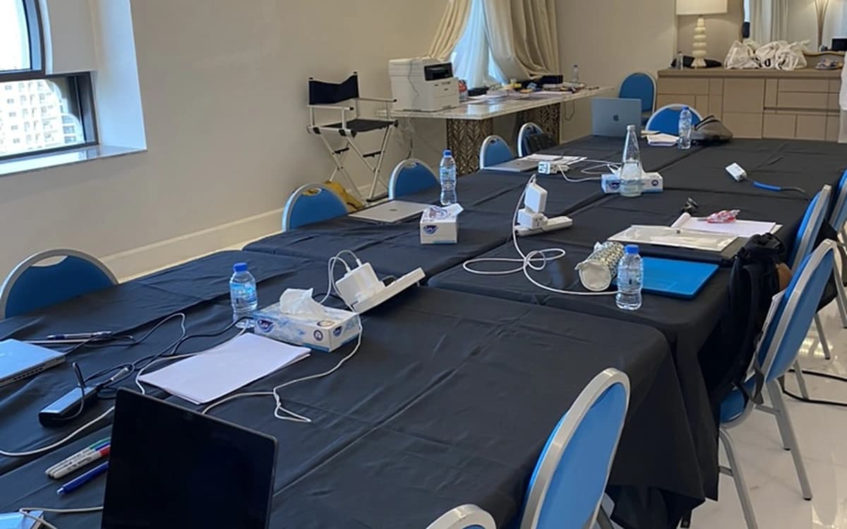 Production meeting room in the UAE with conference tables, reference boards, water, flowers, and planning materials.