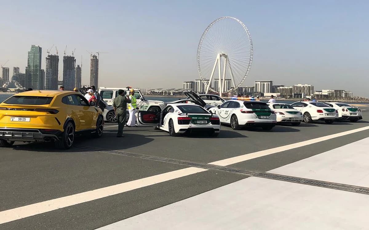 Vehicle filming setup in Dubai with production crew, cars, road space, and Ain Dubai visible in the background.
