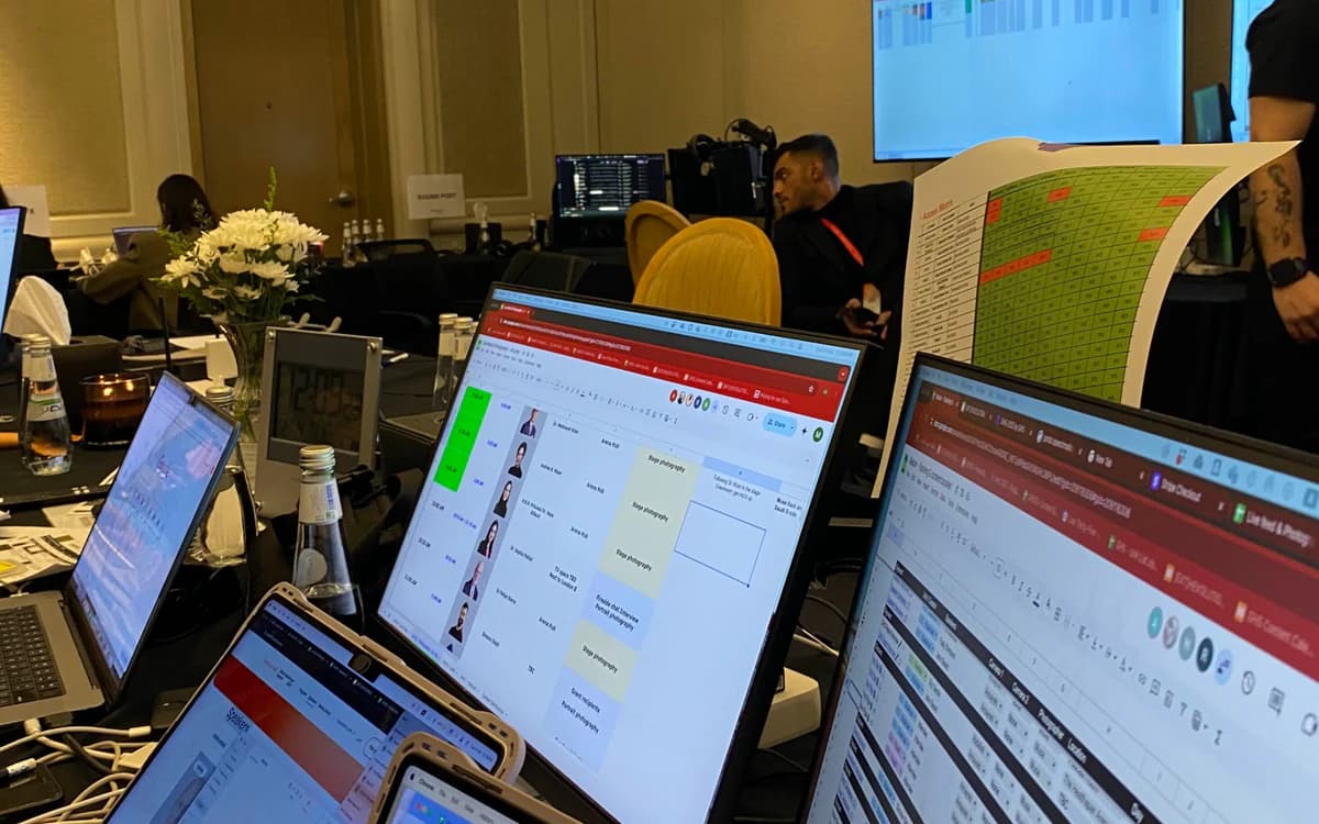Event content production room in the UAE with laptops, schedules, monitors, crew, and live coordination materials.