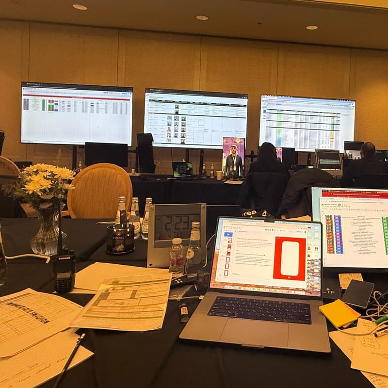 Live content production room in Riyadh with crew, laptops, wall monitors, schedules, edit screens, and production workflow documents.