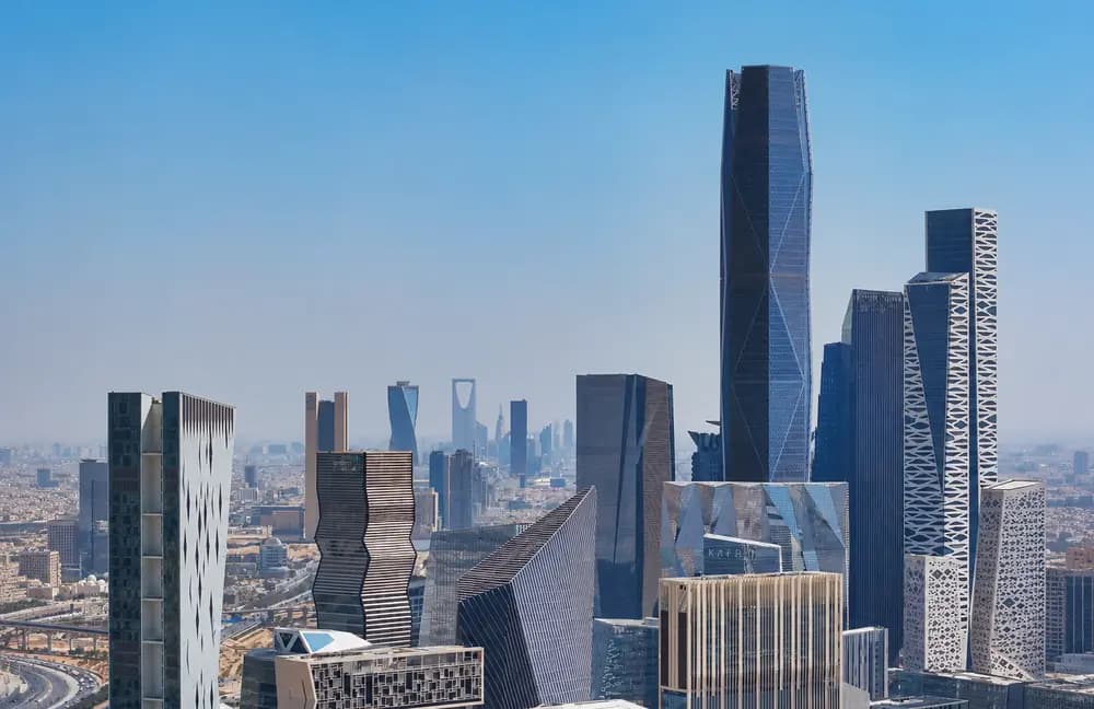 Riyadh skyline with modern business towers and King Abdullah Financial District buildings under a clear blue sky.