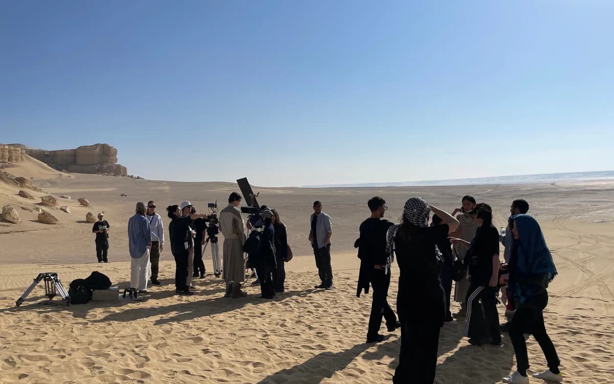 Film crew and talent gathered on a desert location in Jordan with camera equipment and on-set production support.