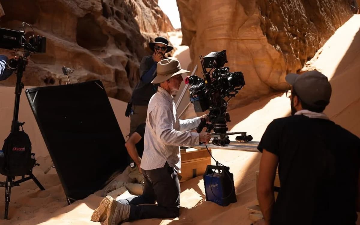Camera crew operating a cinema camera in a sandstone canyon during a desert production in Jordan.