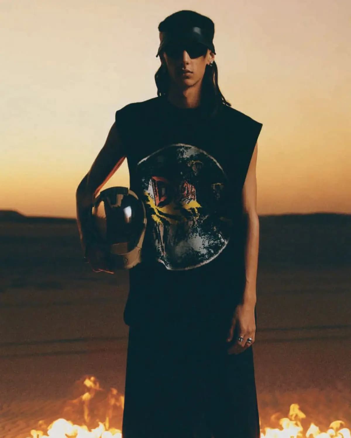Dior Magazine #42 poster showing a fashion model holding a helmet in a desert setting with firelight in the foreground.