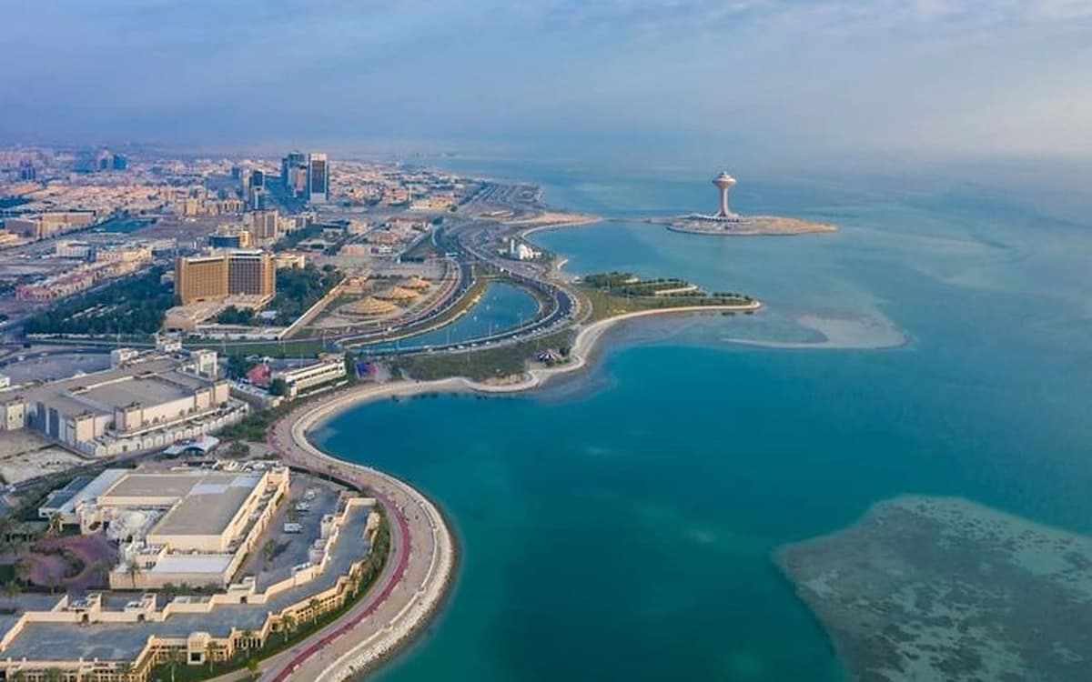Aerial view of Al Khobar seafront with coastal roads, blue Gulf water, city buildings, and waterfront islands.