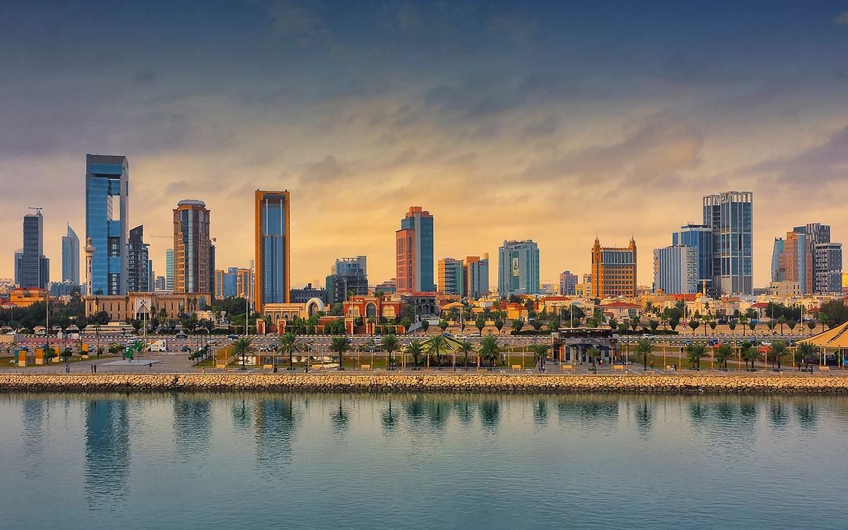 Al Khobar waterfront skyline in Saudi Arabia with modern towers, palm-lined coast, Gulf water, and sunset light.