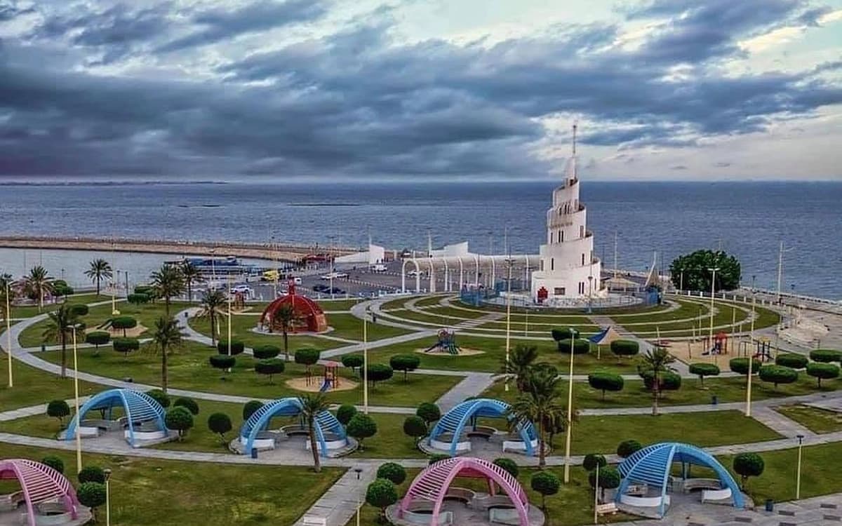 Dammam waterfront park in Saudi Arabia with white seaside monument, landscaped paths, play structures, and Gulf view.