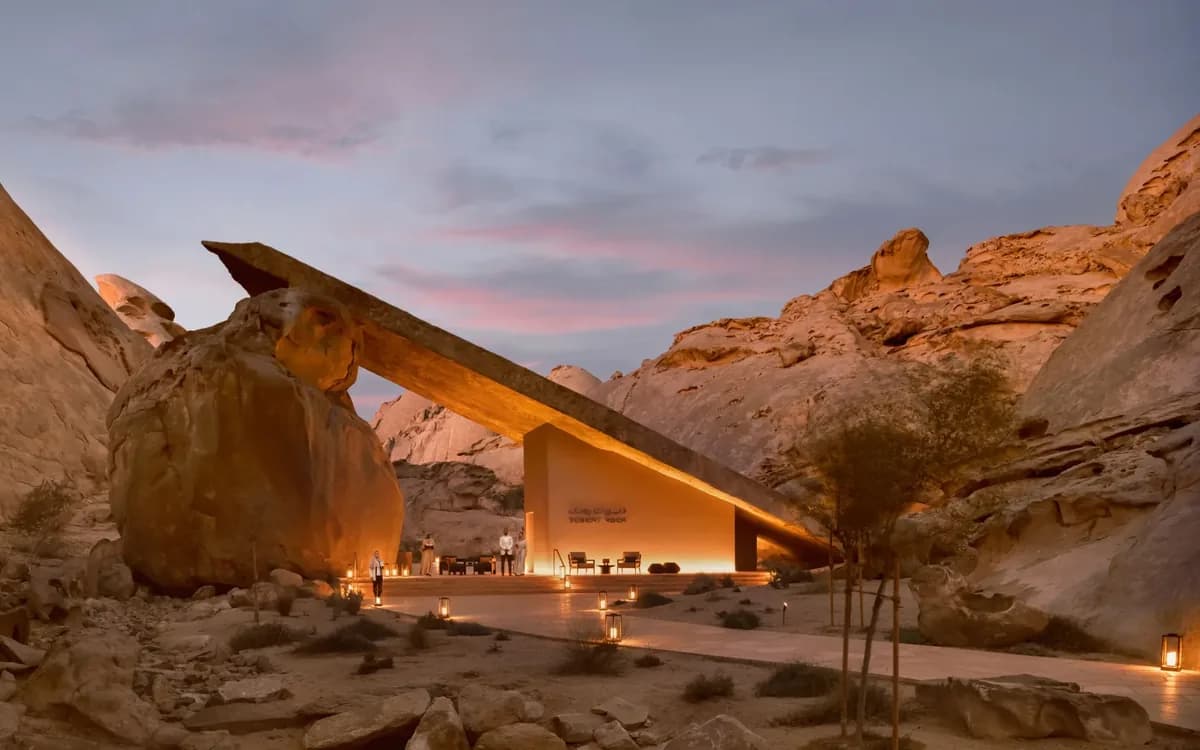 Desert Rock in Saudi Arabia with modern resort architecture set between sandstone boulders and warm evening light.