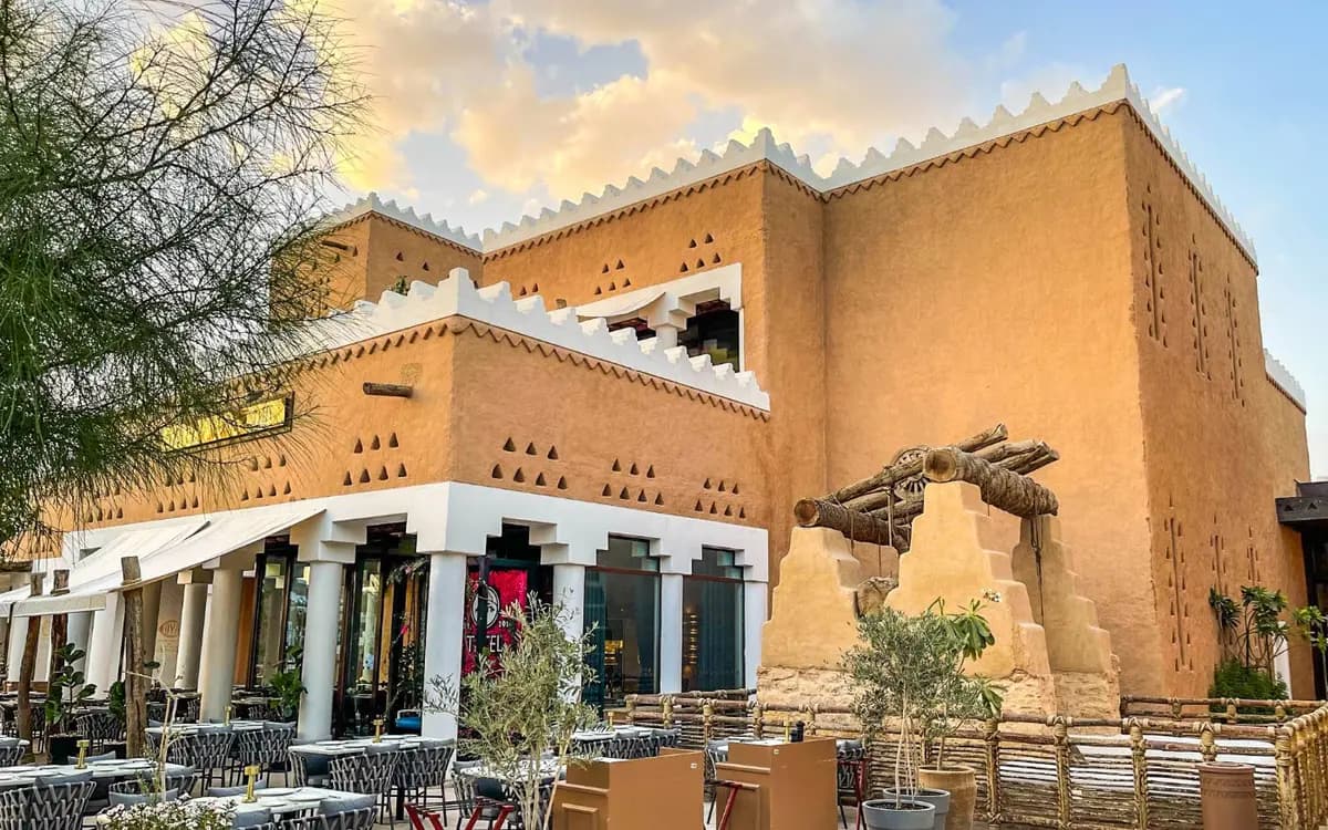 Diriyah heritage district in Saudi Arabia with Najdi-style mud-brick architecture, outdoor seating, and warm evening light.