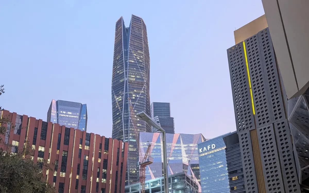 King Abdullah Financial District in Riyadh with modern towers, glass buildings, landscaped walkways, and evening city light.