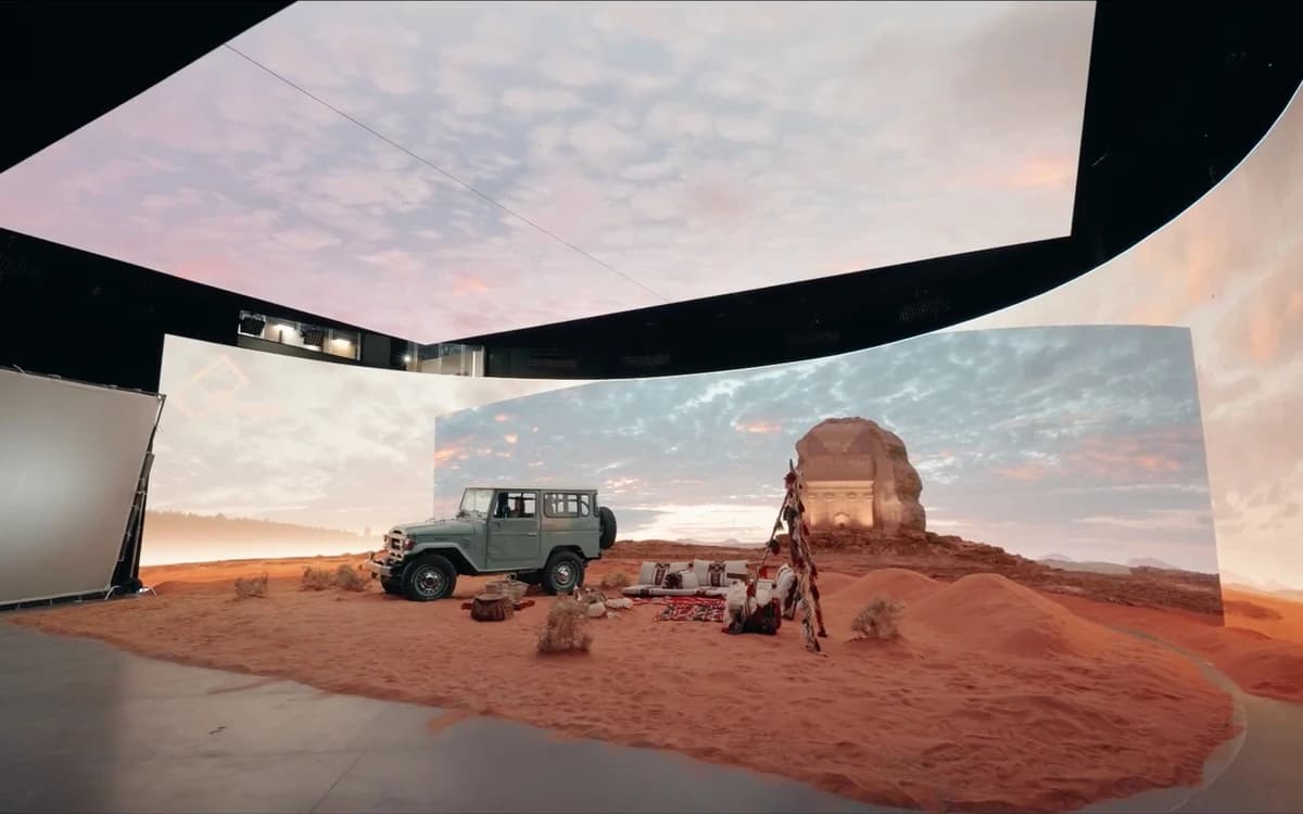 LED volume studio in Saudi Arabia with curved digital screens, desert set, vehicle, sand floor, and production lighting.