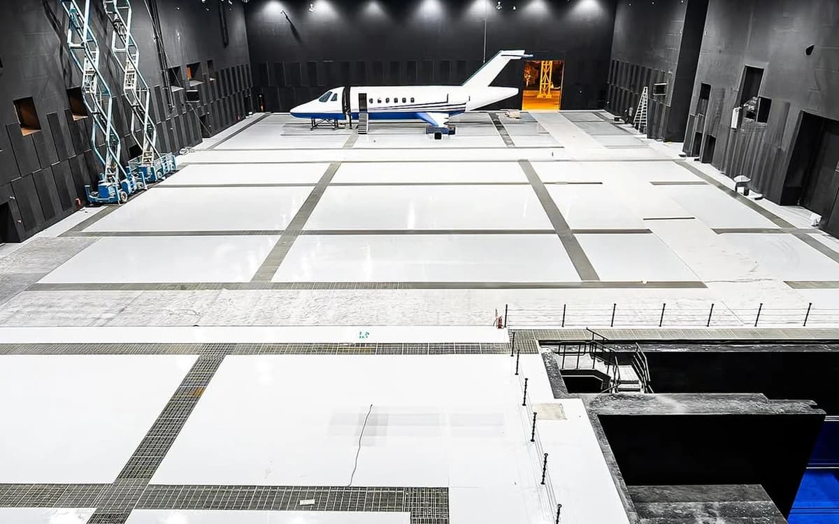 Large soundstage in Saudi Arabia with wide production floor, overhead rigging, aircraft set piece, and controlled studio environment.