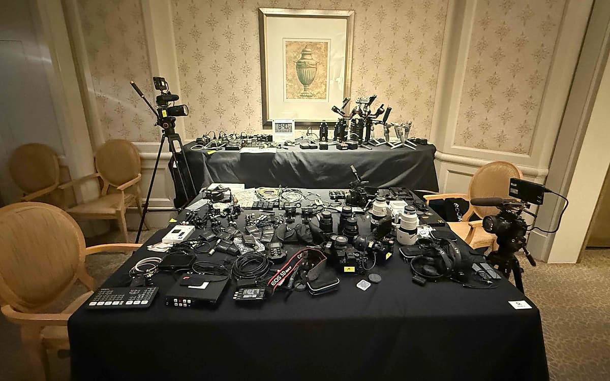 Camera and technical equipment prep room in Saudi Arabia with cameras, lenses, monitors, cables, batteries, and production accessories arranged on tables.