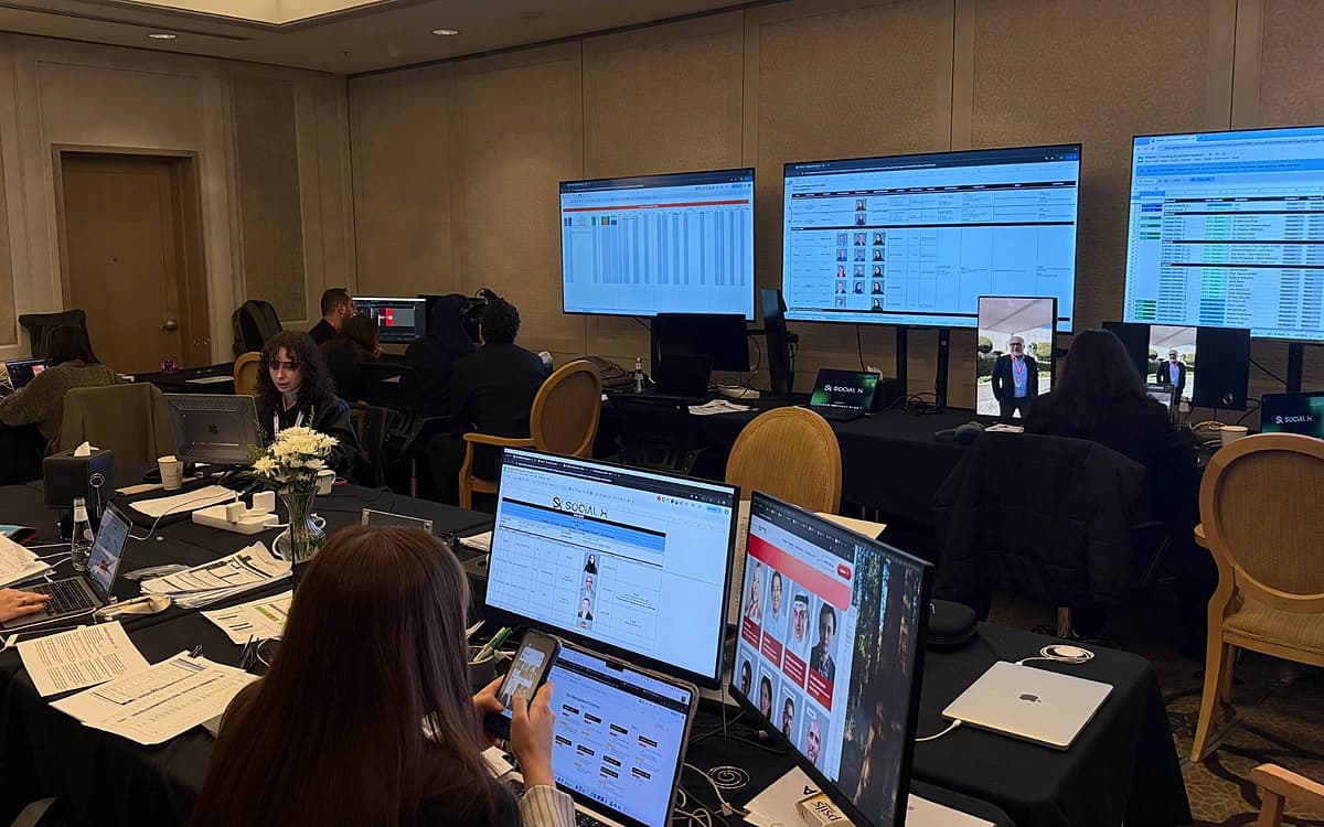 Event content production room in Saudi Arabia with laptops, schedules, monitoring screens, and crew coordinating live media coverage.