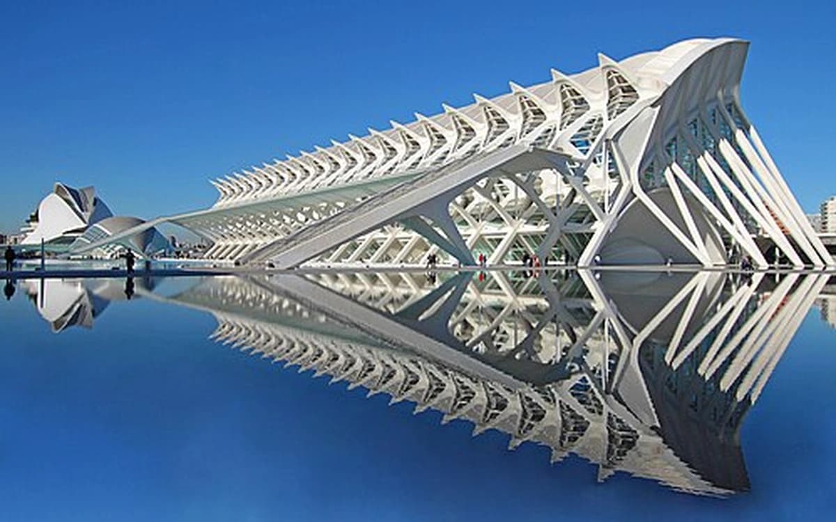 Príncipe Felipe Science Museum at Valencia City of Arts and Sciences reflected in calm water under a clear blue sky.