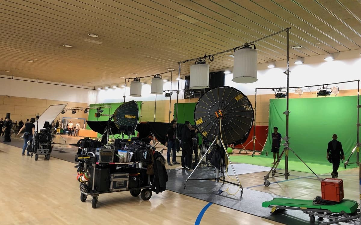 Green screen production setup in Barcelona with lighting rigs, diffusion, camera equipment, crew, and studio floor infrastructure.